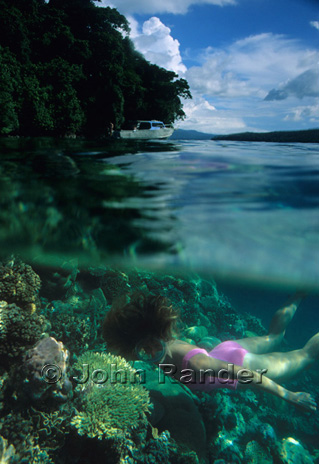 Une apnéiste admirant les jolis coraux de l’ile de Restorff, Baie de Kimbe, Papouasie-Nouvelle-Guinée